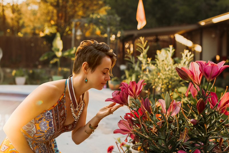 Mary Marie pausing to smell garden lilies in the golden evening light